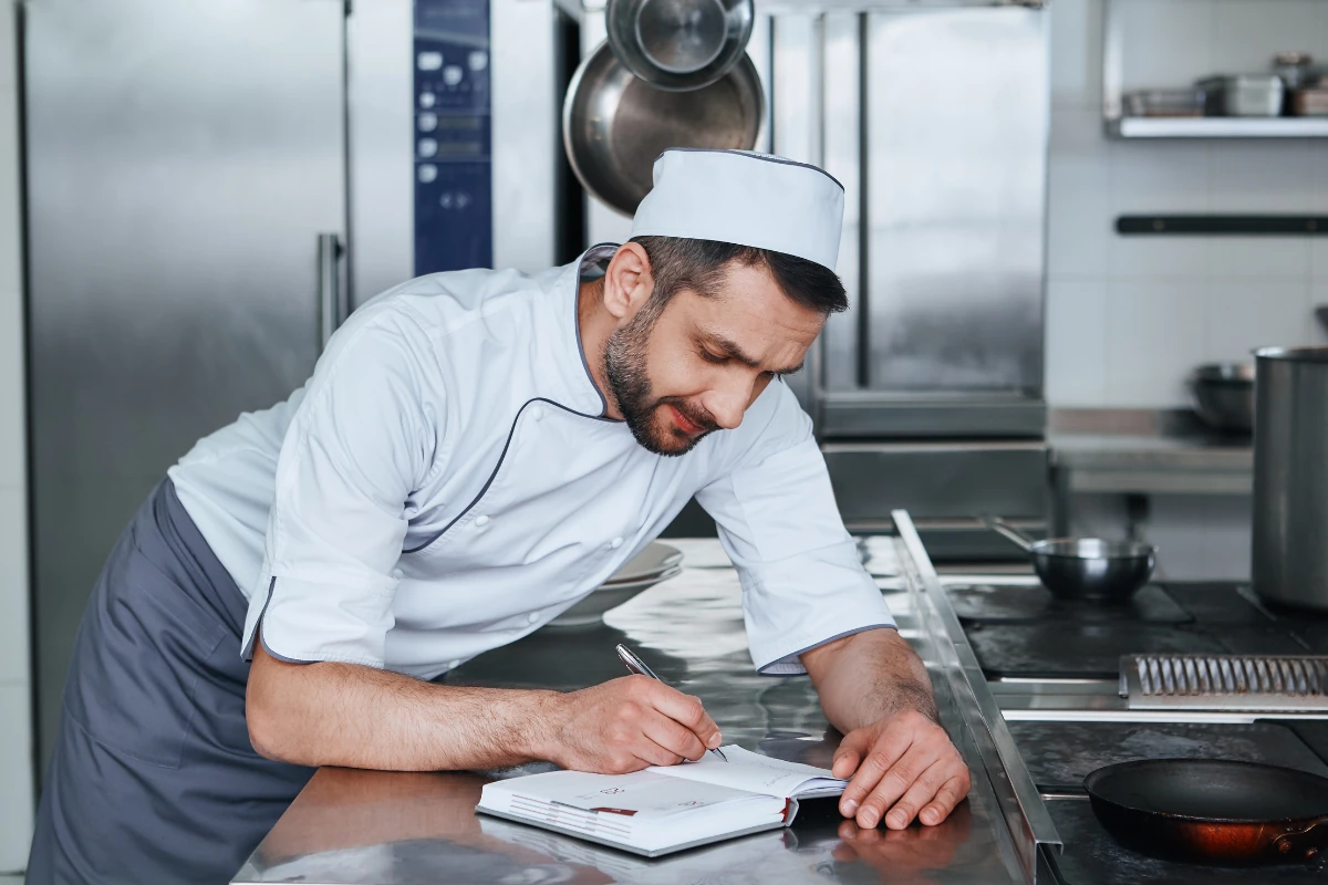 A cook filling Temperature Logs in a Kitchen